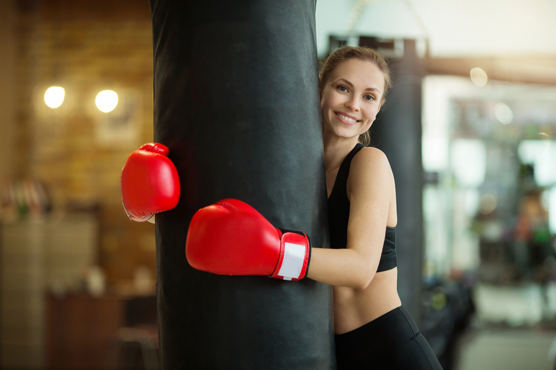 Strike & Shape: Frauenfitness in Bamberg – Frau mit Boxhandschuhen am Sandsack bei GYMRAY