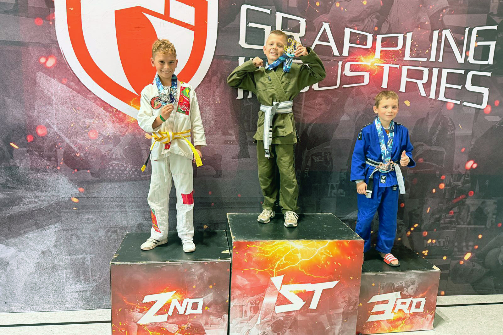 Oskar Rohrig von GYMRAY Bamberg im grünen Gi steht mit Goldmedaille auf dem obersten Treppchen bei Grappling Industries Nürnberg.